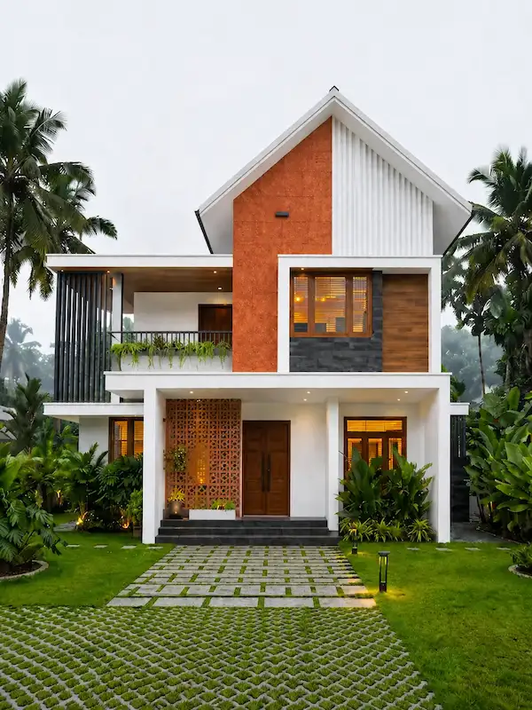 Kerala-style two-storey house with terracotta facade, jali screen entrance, and landscaped garden in Chennai by FIYO Studio